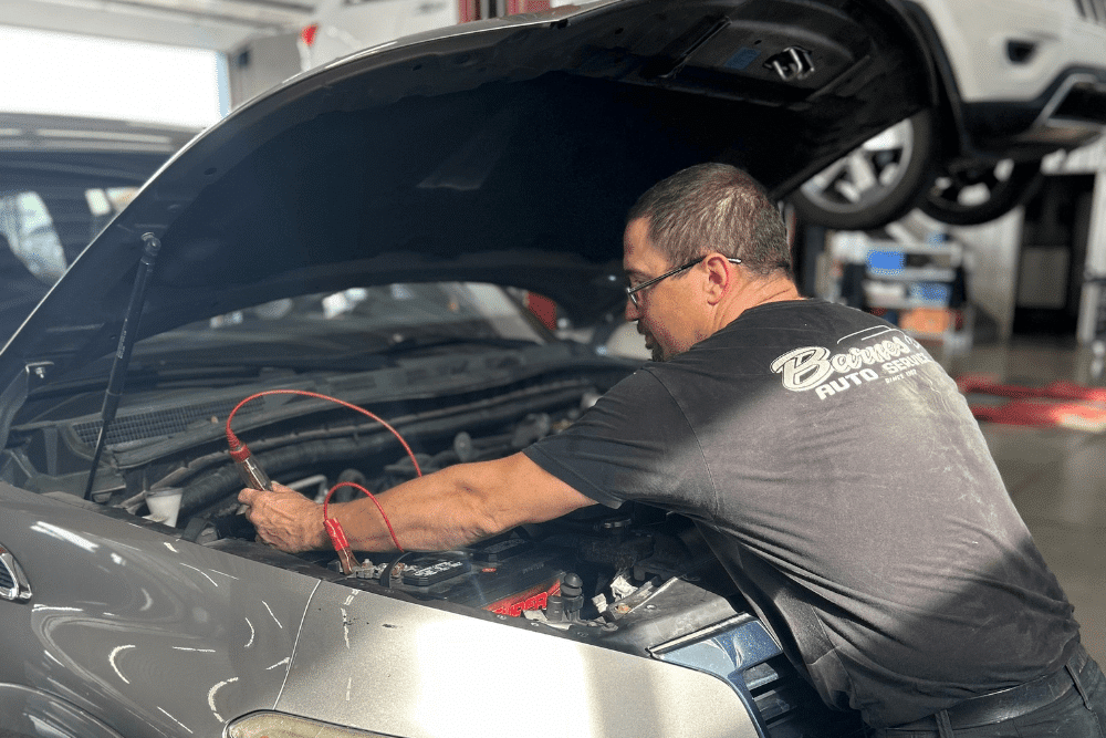 Auto electrical repair, auto repair in Louisville, KY by Barnes Auto Service. Image of a technician inspecting a vehicle’s battery with diagnostic tools connected. Highlighting Barnes Auto Service’s commitment to accurate troubleshooting and dependable engine performance.